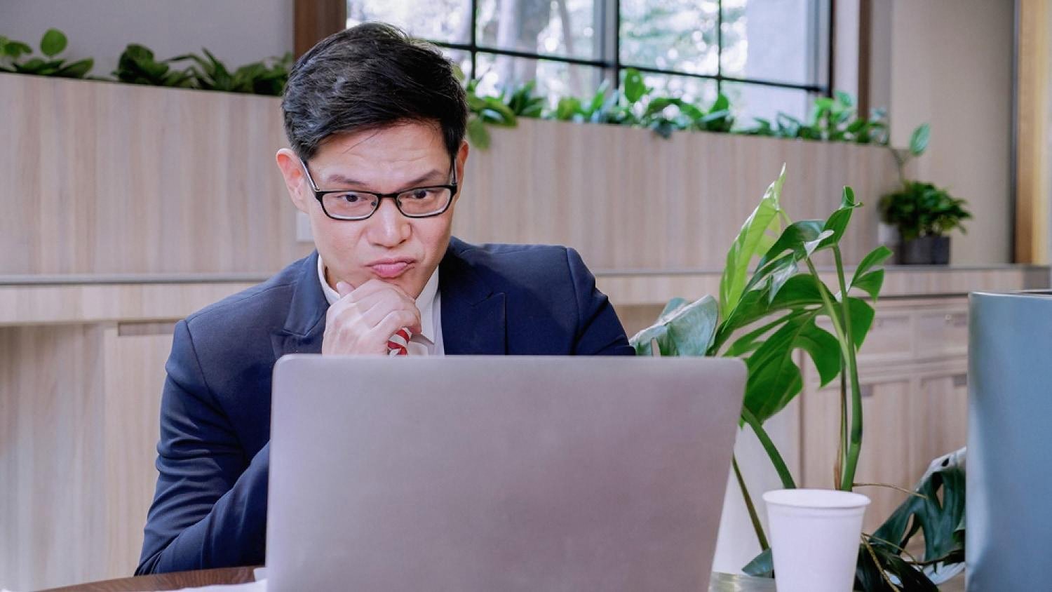 An office worker in the UAE focused on his laptop in a modern workspace